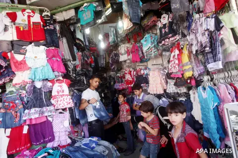 A Palestinian vendor displays his goods at a market in Gaza city on Aug 13,2012, as Muslims over the world prepare to celebrate Eid al-Fitr, a three day holiday marking the end of the religious month of Ramadan in which...