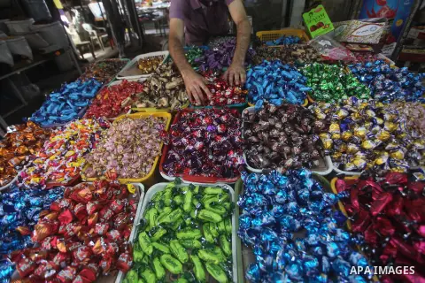 A Palestinian vendor displays his goods at a market in Gaza city on Aug 13,2012, as Muslims over the world prepare to celebrate Eid al-Fitr, a three day holiday marking the end of the religious month of Ramadan in which...