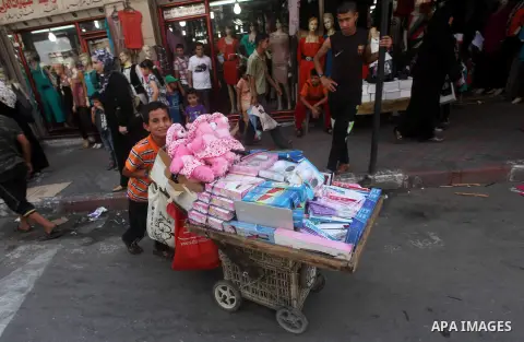 A Palestinian child sells toys at a market in Gaza city on Aug 13,2012, as Muslims over the world prepare to celebrate Eid al-Fitr, a three day holiday marking the end of the religious month of Ramadan in which believers...