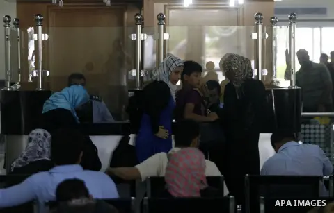 Palestinian passengers wait at a station in Khan Younis in the southern Gaza Strip, before entering Egypt through Rafah border crossing August 14, 2012. Egypt opened the crossing temporarily on Tuesday, but just for thre...
