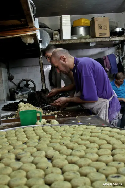 Palestinians vendor make traditional nut cookies before the upcoming Eid al-Fitr holidays at a bakery in the West Bank city of Nablus, on Aug. 14, 2012. Muslims will celebrate Eid al-Fitr that marks the end of the fastin...