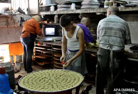 Palestinians vendor make traditional nut cookies before the upcoming Eid al-Fitr holidays at a bakery in the West Bank city of Nablus, on Aug. 14, 2012. Muslims will celebrate Eid al-Fitr that marks the end of the fastin...