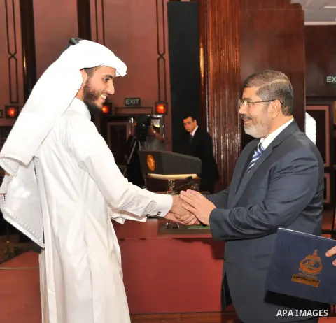 Egypt's President Mohamed Mursi, presents a prize to a youth who won the Conservation of the Holy Koran contest during the Laylat al-Qadr at Egypt Al-Azhar Conference Center at Nasr City in Cairo August 12, 2012. Egypt's...