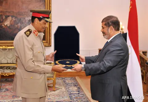 Former Defense Minister Hussein Tantawi, left, receives a high medal from Egyptian President Mohammed Morsi at the Presidential Palace in Cairo, Egypt, Tuesday, Aug. 14, 2012. Egypt's president has given awards to the na...