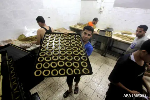 Palestinian workers make traditional date-filled cookies in preparation for the Eid al-Fitr holiday at bakery in the Gaza Strip on August 16, 2012. Muslims around the world are preparing to celebrate the Eid al-Fitr holi...