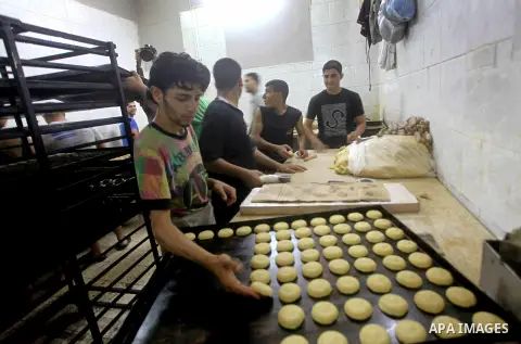 Palestinian workers make traditional date-filled cookies in preparation for the Eid al-Fitr holiday at bakery in the Gaza Strip on August 16, 2012. Muslims around the world are preparing to celebrate the Eid al-Fitr holi...