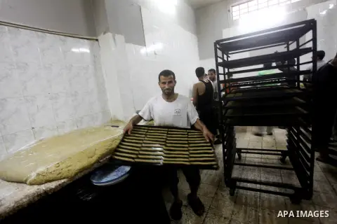 Palestinian workers make traditional date-filled cookies in preparation for the Eid al-Fitr holiday at bakery in the Gaza Strip on August 16, 2012. Muslims around the world are preparing to celebrate the Eid al-Fitr holi...
