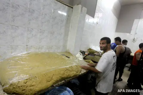 Palestinian workers make traditional date-filled cookies in preparation for the Eid al-Fitr holiday at bakery in the Gaza Strip on August 16, 2012. Muslims around the world are preparing to celebrate the Eid al-Fitr holi...