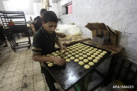 Palestinian workers make traditional date-filled cookies in preparation for the Eid al-Fitr holiday at bakery in the Gaza Strip on August 16, 2012. Muslims around the world are preparing to celebrate the Eid al-Fitr holi...