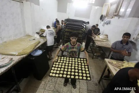Palestinian workers make traditional date-filled cookies in preparation for the Eid al-Fitr holiday at bakery in the Gaza Strip on August 16, 2012. Muslims around the world are preparing to celebrate the Eid al-Fitr holi...