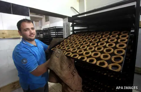 Palestinian workers make traditional date-filled cookies in preparation for the Eid al-Fitr holiday at bakery in the Gaza Strip on August 16, 2012. Muslims around the world are preparing to celebrate the Eid al-Fitr holi...