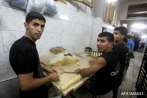 Palestinian workers make traditional date-filled cookies in preparation for the Eid al-Fitr holiday at bakery in the Gaza Strip on August 16, 2012. Muslims around the world are preparing to celebrate the Eid al-Fitr holi...