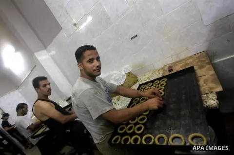 Palestinian workers make traditional date-filled cookies in preparation for the Eid al-Fitr holiday at bakery in the Gaza Strip on August 16, 2012. Muslims around the world are preparing to celebrate the Eid al-Fitr holi...