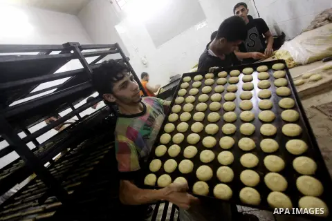 Palestinian workers make traditional date-filled cookies in preparation for the Eid al-Fitr holiday at bakery in the Gaza Strip on August 16, 2012. Muslims around the world are preparing to celebrate the Eid al-Fitr holi...