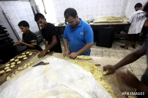 Palestinian workers make traditional date-filled cookies in preparation for the Eid al-Fitr holiday at bakery in the Gaza Strip on August 16, 2012. Muslims around the world are preparing to celebrate the Eid al-Fitr holi...