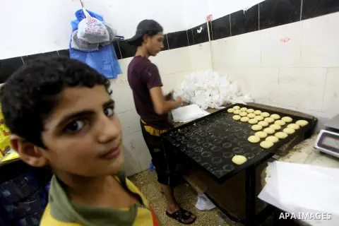 Palestinian workers make traditional date-filled cookies in preparation for the Eid al-Fitr holiday at bakery in the Gaza Strip on August 16, 2012. Muslims around the world are preparing to celebrate the Eid al-Fitr holi...