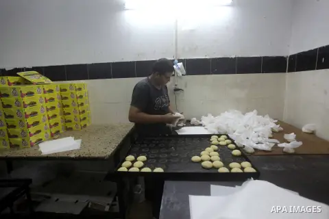 Palestinian workers make traditional date-filled cookies in preparation for the Eid al-Fitr holiday at bakery in the Gaza Strip on August 16, 2012. Muslims around the world are preparing to celebrate the Eid al-Fitr holi...