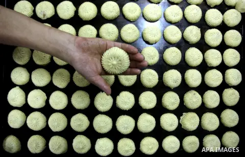Palestinian workers make traditional date-filled cookies in preparation for the Eid al-Fitr holiday at bakery in the Gaza Strip on August 16, 2012. Muslims around the world are preparing to celebrate the Eid al-Fitr holi...