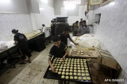 Palestinian workers make traditional date-filled cookies in preparation for the Eid al-Fitr holiday at bakery in the Gaza Strip on August 16, 2012. Muslims around the world are preparing to celebrate the Eid al-Fitr holi...
