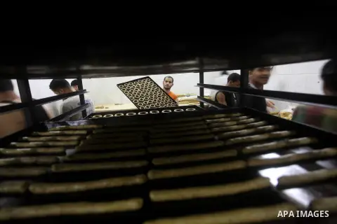 Palestinian workers make traditional date-filled cookies in preparation for the Eid al-Fitr holiday at bakery in the Gaza Strip on August 16, 2012. Muslims around the world are preparing to celebrate the Eid al-Fitr holi...