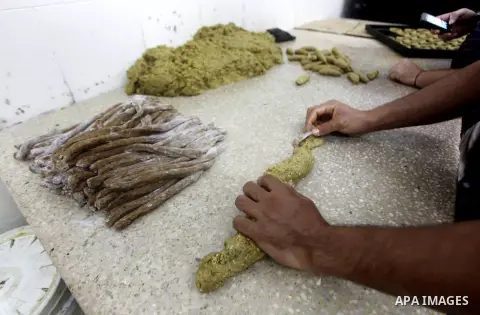 Palestinian workers make traditional date-filled cookies in preparation for the Eid al-Fitr holiday at bakery in the Gaza Strip on August 16, 2012. Muslims around the world are preparing to celebrate the Eid al-Fitr holi...