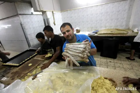 Palestinian workers make traditional date-filled cookies in preparation for the Eid al-Fitr holiday at bakery in the Gaza Strip on August 16, 2012. Muslims around the world are preparing to celebrate the Eid al-Fitr holi...