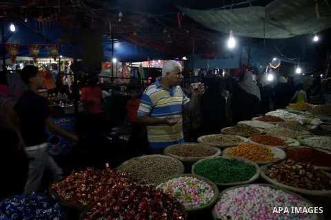 A Palestinian vendor displays his goods at a market in the southern Gaza strip town of Rafah on Aug 16,2012, as Muslims over the world prepare to celebrate Eid al-Fitr, a three day holiday marking the end of the religiou...