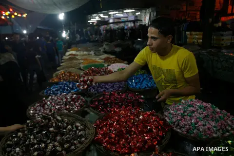 A Palestinian vendor displays his goods at a market in the southern Gaza strip town of Rafah on Aug 16,2012, as Muslims over the world prepare to celebrate Eid al-Fitr, a three day holiday marking the end of the religiou...