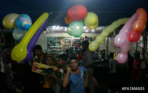 Palestinian children buy toys at a market in the southern Gaza strip town of Rafah on Aug 16,2012, as Muslims over the world prepare to celebrate Eid al-Fitr, a three day holiday marking the end of the religious month of...
