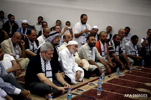 The spokesman of the Palestinian parliament, Ahmed Bahr (C) meets with members of the members "Miles of Smiles 15" aid convoy at a mosque before breaking their fast during the holy month of Ramadan in Gaza city, on Aug 1...