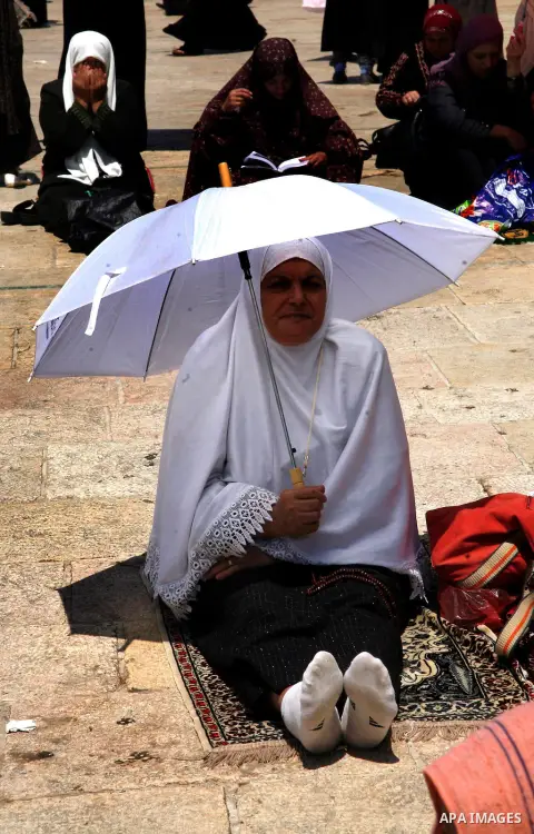 A Palestinian Muslim woman prays outside the Dome of the Rock at al-Aqsa mosque compound, Islam's third holiest site, on August 17, 2012, in the old city of Jerusalem, on the last Friday of the Muslim holy fasting month...