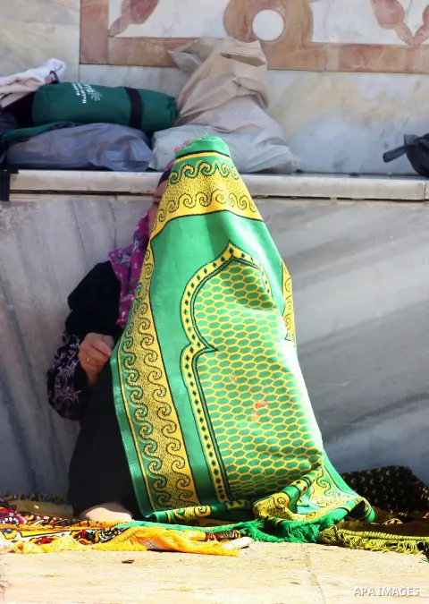 A Palestinian woman prays outside the Dome of the Rock at al-Aqsa mosque compound, Islam's third holiest site, on August 17, 2012, in the old city of Jerusalem, on the last Friday of the Muslim holy fasting month of Rama...