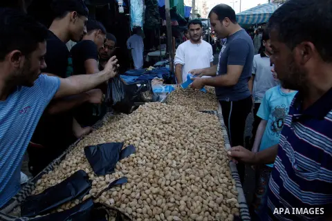 A Palestinian vendor sells nuts at a market in the southern Gaza strip town of Rafah on Aug 17,2012, as Muslims over the world prepare to celebrate Eid al-Fitr, a three day holiday marking the end of the religious month...