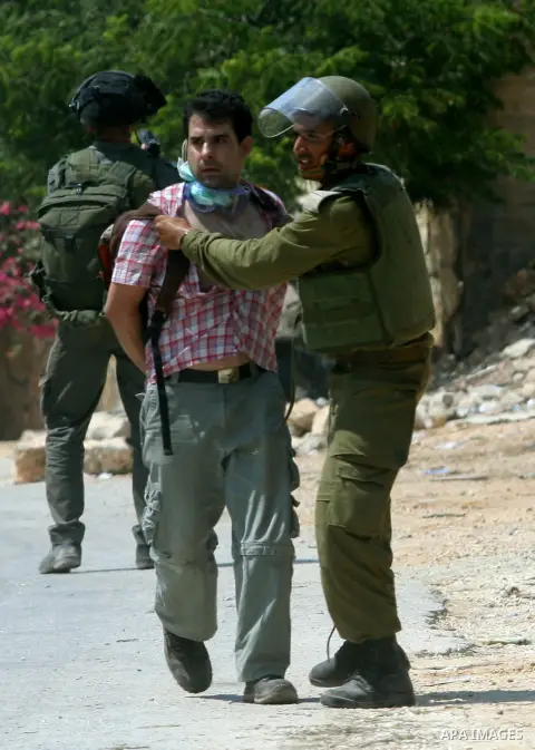 An Israeli soldier detains a Palestinian protestor during a demonstration against the expropriation of Palestinian land by Israel in the village of Kfar Qaddum, near the West Bank city of Nablus, on August 17, 2012. Phot...