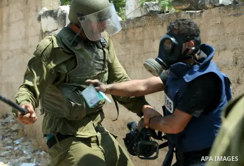 An Israeli soldier hits a Palestinian press photographer during a demonstration against the expropriation of Palestinian land by Israel in the village of Kfar Qaddum, near the West Bank city of Nablus, on August 17, 2012...