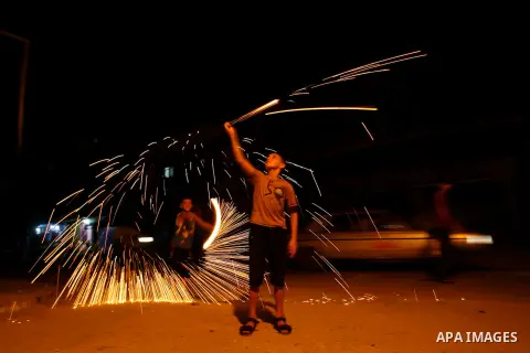 A Palestinian child lights fireworks in Rafah in south of Gaza Strip on 17 August 2012, as Muslims over the world prepare to celebrate Eid al-Fitr, a three day holiday marking the end of the religious month of Ramadan in...