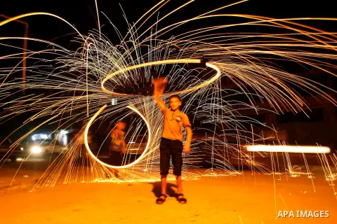 A Palestinian child lights fireworks in Rafah in south of Gaza Strip on 17 August 2012, as Muslims over the world prepare to celebrate Eid al-Fitr, a three day holiday marking the end of the religious month of Ramadan in...