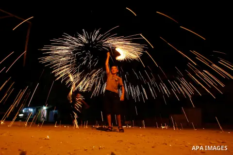 A Palestinian child lights fireworks in Rafah in south of Gaza Strip on 17 August 2012, as Muslims over the world prepare to celebrate Eid al-Fitr, a three day holiday marking the end of the religious month of Ramadan in...