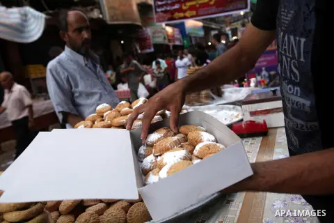 A Palestinian vendor sells the cakes at the main market during preparations for the Eid Al-Fitr feast Gaza city on Aug 18, 2012, as Muslims over the world prepare to celebrate Eid al-Fitr, a three day holiday marking the...