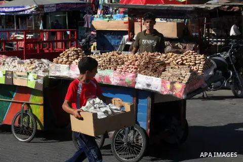 A Palestinian vendor displays the cakes at the main market during preparations for the Eid Al-Fitr feast Gaza city on Aug 18, 2012, as Muslims over the world prepare to celebrate Eid al-Fitr, a three day holiday marking...