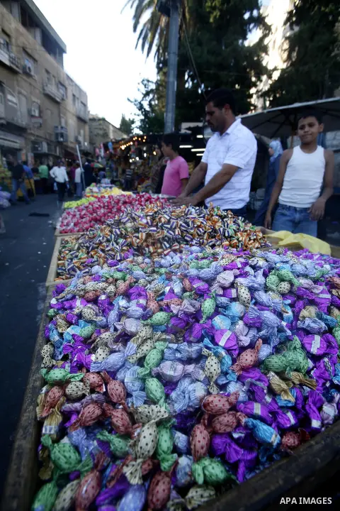 A Palestinian vendor sells candy in the market during preparations for the Eid Al-Fitr feast in Jerusalem's Old City on Aug 16, 2012, as Muslims over the world prepare to celebrate Eid al-Fitr, a three day holiday markin...
