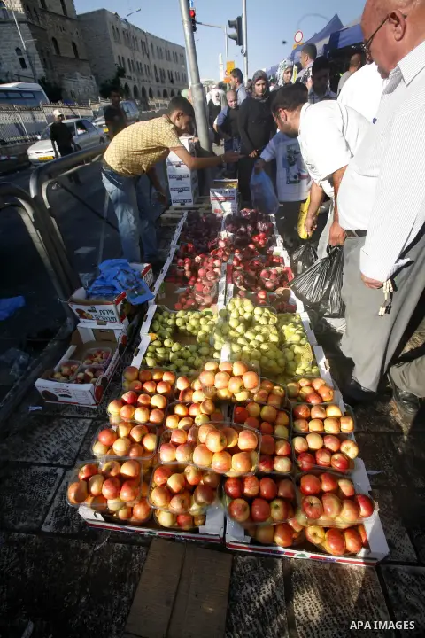 A Palestinian vendor sells fruits in the market during preparations for the Eid Al-Fitr feast in Jerusalem's Old City on Aug 16, 2012, as Muslims over the world prepare to celebrate Eid al-Fitr, a three day holiday marki...