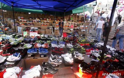 A Palestinian vendor sells shoes in the market during preparations for the Eid Al-Fitr feast in Jerusalem's Old City on Aug 16, 2012, as Muslims over the world prepare to celebrate Eid al-Fitr, a three day holiday markin...
