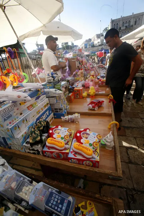 A Palestinian vendor sells toys in the market during preparations for the Eid Al-Fitr feast in Jerusalem's Old City on Aug 16, 2012, as Muslims over the world prepare to celebrate Eid al-Fitr, a three day holiday marking...