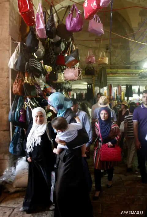 Palestinians shop at the market during preparations for the Eid Al-Fitr feast in Jerusalem's Old City on Aug 16, 2012, as Muslims over the world prepare to celebrate Eid al-Fitr, a three day holiday marking the end of th...