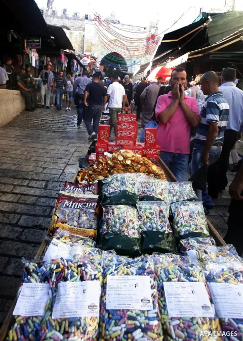 A Palestinian vendor sells candy in the market during preparations for the Eid Al-Fitr feast in Jerusalem's Old City on Aug 16, 2012, as Muslims over the world prepare to celebrate Eid al-Fitr, a three day holiday markin...