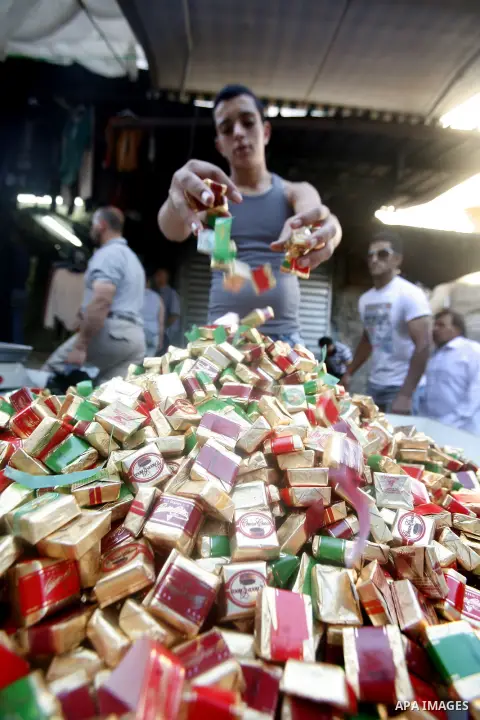 A Palestinian vendor sells candy in the market during preparations for the Eid Al-Fitr feast in Jerusalem's Old City on Aug 16, 2012, as Muslims over the world prepare to celebrate Eid al-Fitr, a three day holiday markin...