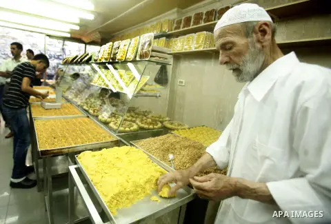 A Palestinian baker makes cake at his shop in the market during preparations for the Eid Al-Fitr feast in Jerusalem's Old City on Aug 16, 2012, as Muslims over the world prepare to celebrate Eid al-Fitr, a three day holi...