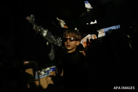 A Palestinian child sells toys in the market during preparations for the Eid Al-Fitr feast in Rafah in the southern of Gaza strip on Aug 16, 2012, as Muslims over the world prepare to celebrate Eid al-Fitr, a three day h...