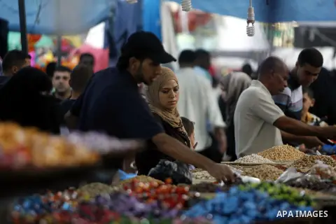 Palestinians shop at the market during preparations for the Eid Al-Fitr feast in Rafah in the southern of Gaza strip on Aug 16, 2012, as Muslims over the world prepare to celebrate Eid al-Fitr, a three day holiday markin...